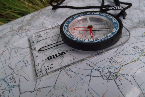 A Silva baseplate style compass on an OS map for navigation.