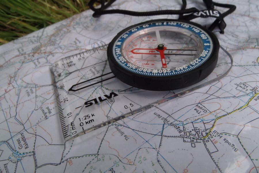 A Silva baseplate style compass on an OS map for navigation.